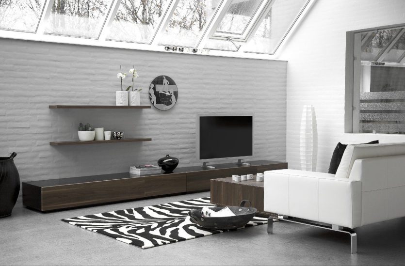 modern living room alternative decor white couch stainless legs wooden coffee table zebra carpet long wooden tv stand cabinetry wall open shelves painted brick wall black frying pan basket glass skyli